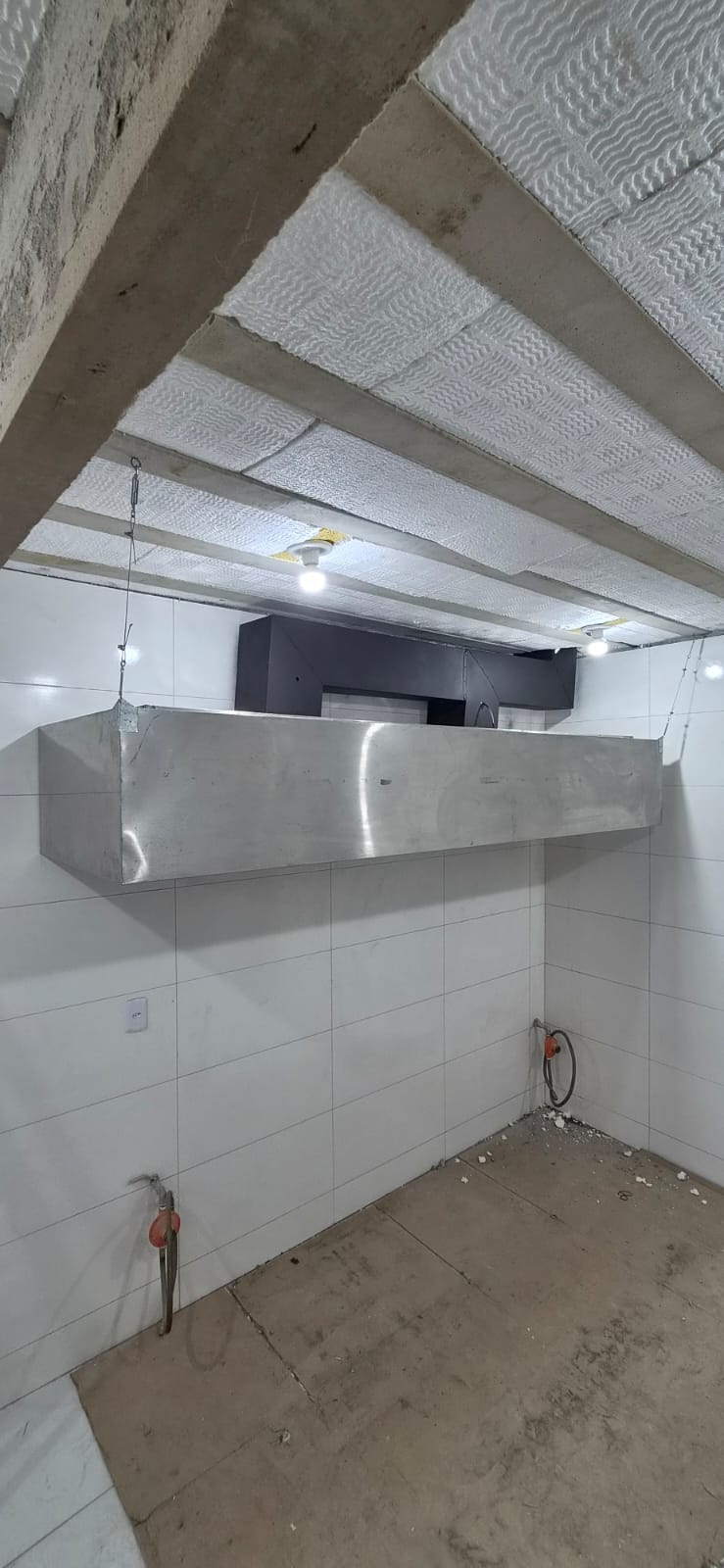 Vista lateral da coifa sob medida fabricada em aço inox para a cozinha do restaurante